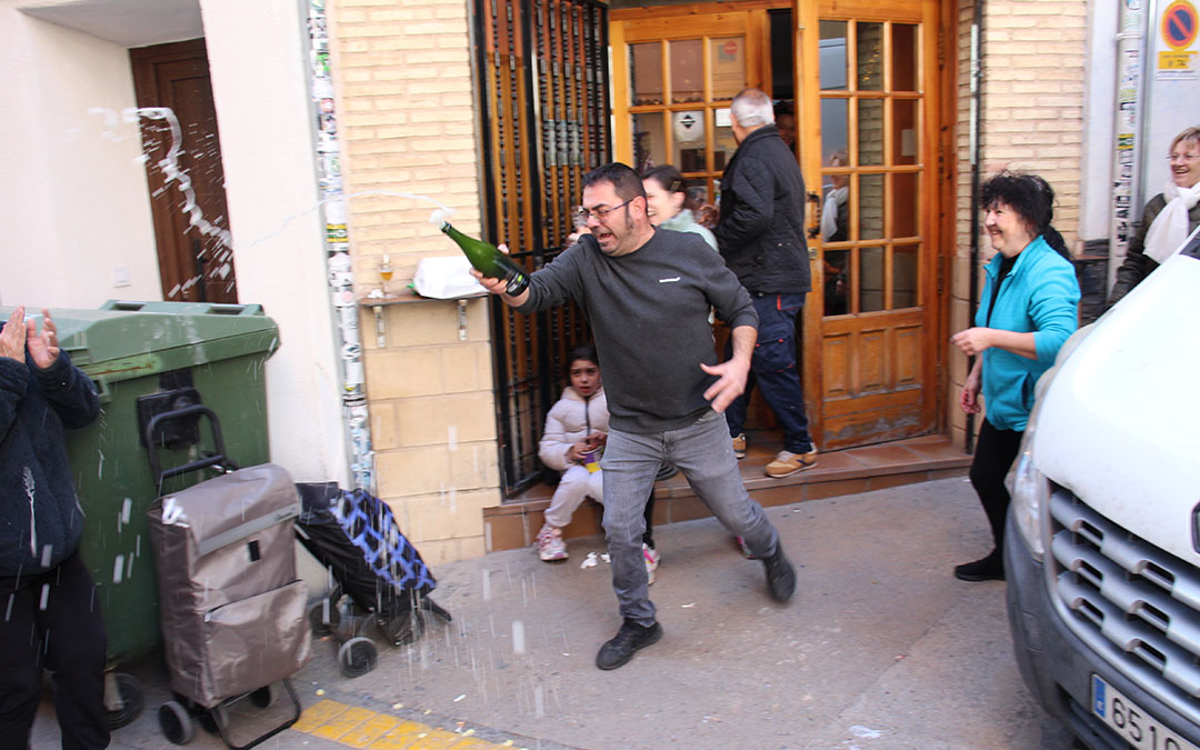 Juan Carlos Elías descorchando el cava. Se desata la locura en Albalate del Arzobispo con el 23112, primer quinto premio, vendido por Pescados Elías. / B. Severino