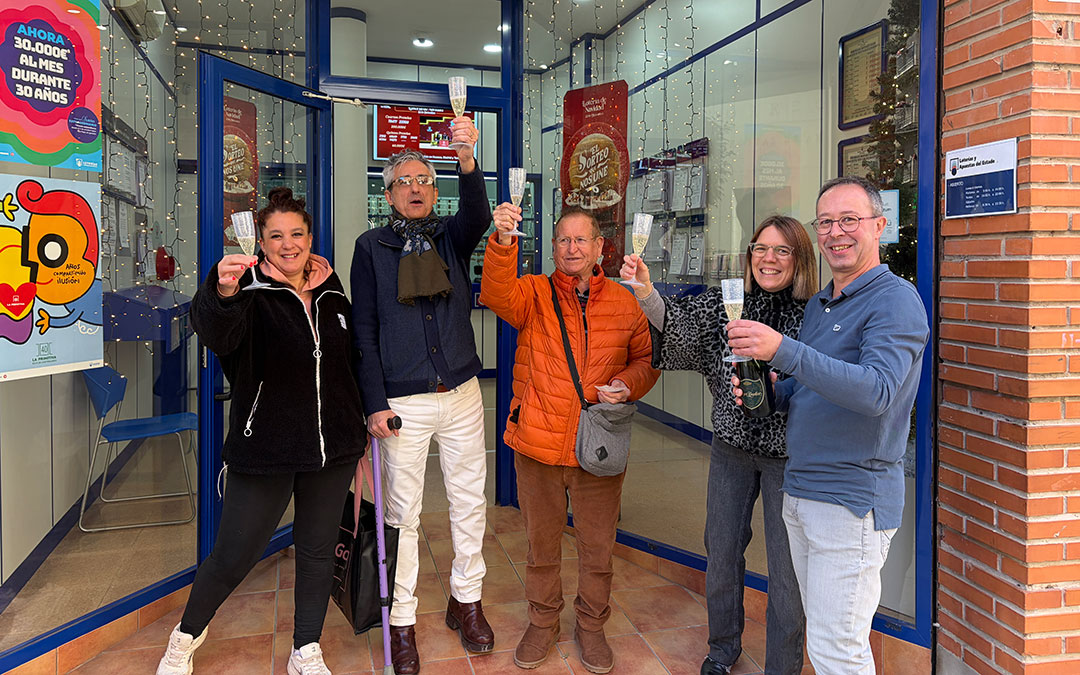 José Manuel Rey, Jesús Angosto y Mariví Esteve junto a dos clientes han salido a celebrar el quinto premio con champán. / A.Z