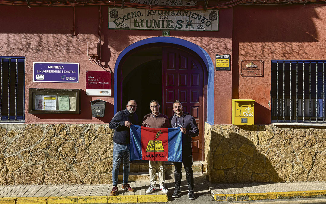 Subteniente Antonio Bello Yus, con la bandera de Muniesa, entre el alcalde, José Luis Iranzo; y el concejal Raúl Blasco / Ayto. Muniesa