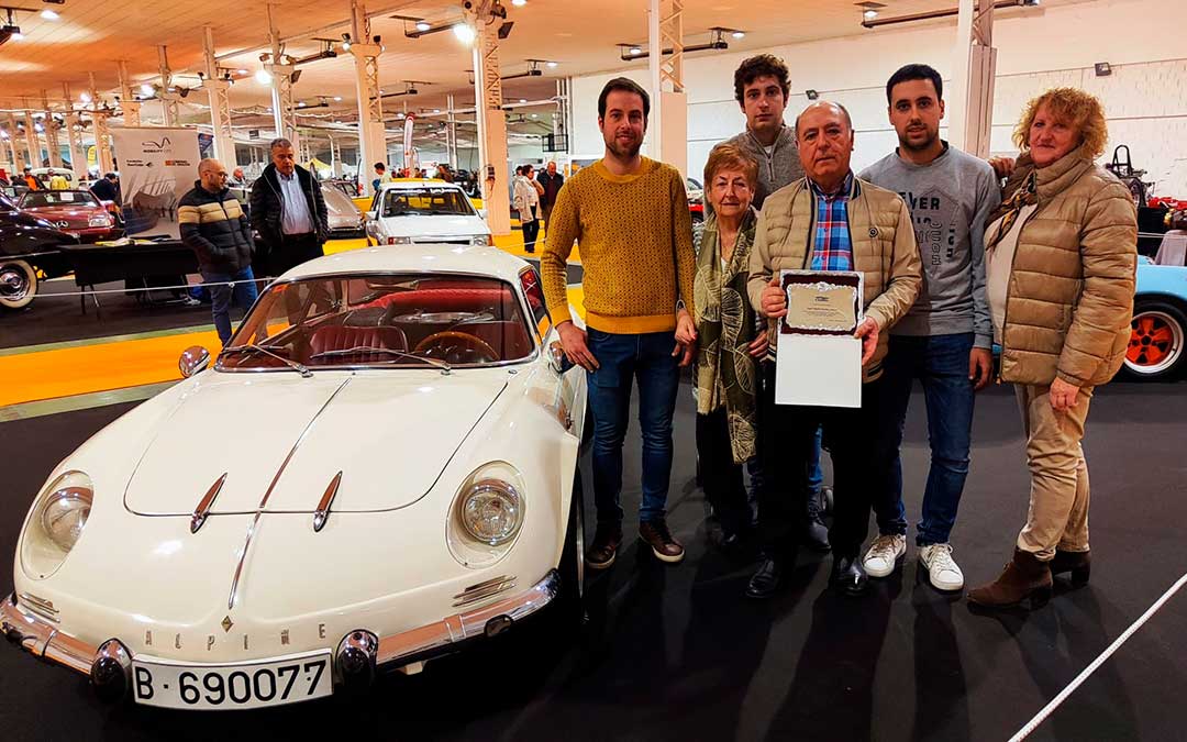 Ángel Martínez 'Pepinero' muestra la placa homenaje de Autoclassic junto a su mujer, su madre y sus hijos junto al primer coche que restauró, un Alpine / A. Gracia
