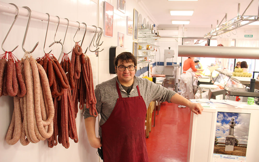 Óscar Soriano, al frente de Carnicería Ariño en Alcañiz en un día de despacho de chorizos, longanizas y "choricetas" y "longanicetas", una versión más pequeña que muchos padres y abuelos se llevan para hijos pequeños y nietos. / B. Severino