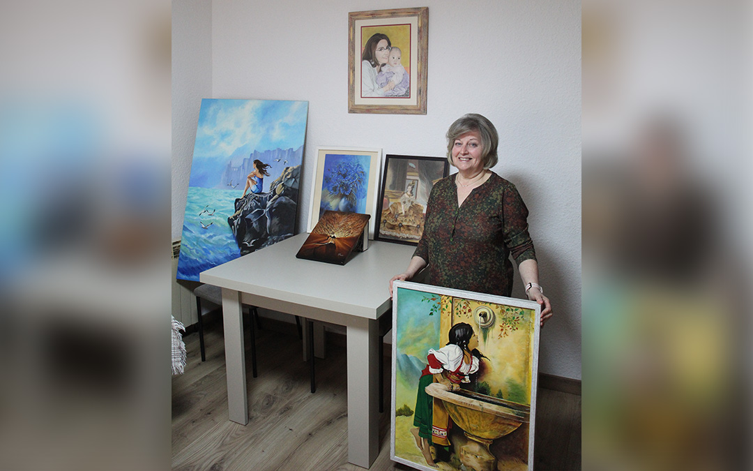 Paquita Barceló ya tenía soltura con la pintura y el dibujo en el colegio, pero no se lanzó hasta hace unos años. En la foto muestra algunas de sus variadas obras en las que hay óleo, pastel y collage en los que mezcla todo eso con la flor prensada. / B. Severino
