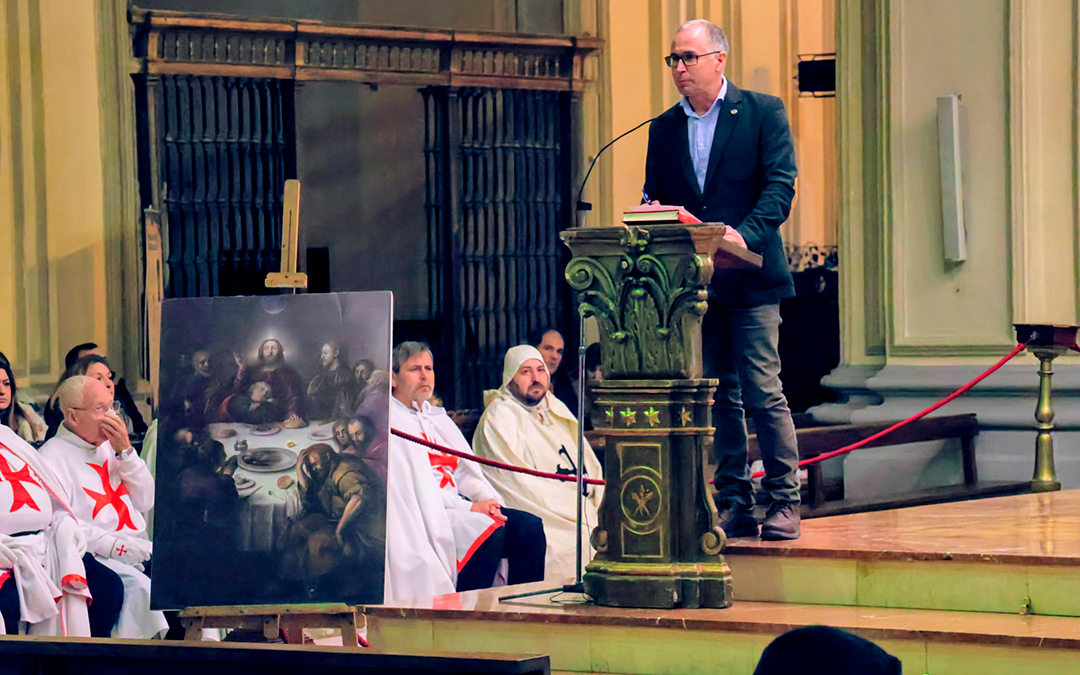 El concejal de Patrimonio de Alcañiz, Carlos Andreu, interviene este domingo en la misa de consagración del lienzo La última cena, ante una réplica del cuadro. / E. M.