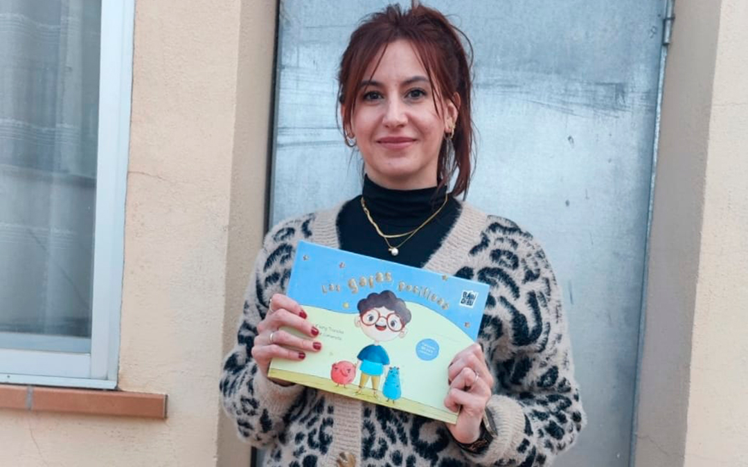 Cristina Escrig, psicóloga sanitaria de ASAPME Bajo Aragón, posa con su libro 'Las gafas positivas'. / Cedida