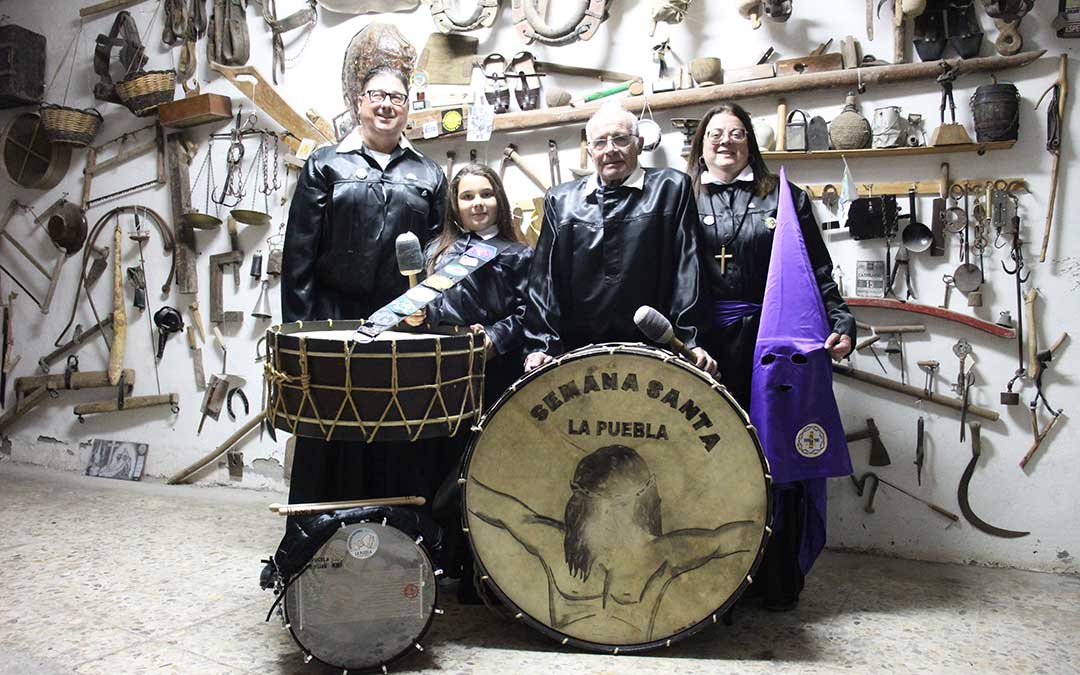 Pedro Salvador Gimeno (1947) posa en su cochera apoyado en el bombo de su hijo, junto a su hija Pili como cofrade del Nazareno; su yerno Roger Balfagón, con su tambor a los pies con la Torica al fondo; y su nieta e hija de ambos, Lucía. Él, a quien las piernas no le aguantan una procesión, sigue saliendo a romper la Hora en la puerta. / B. Severino