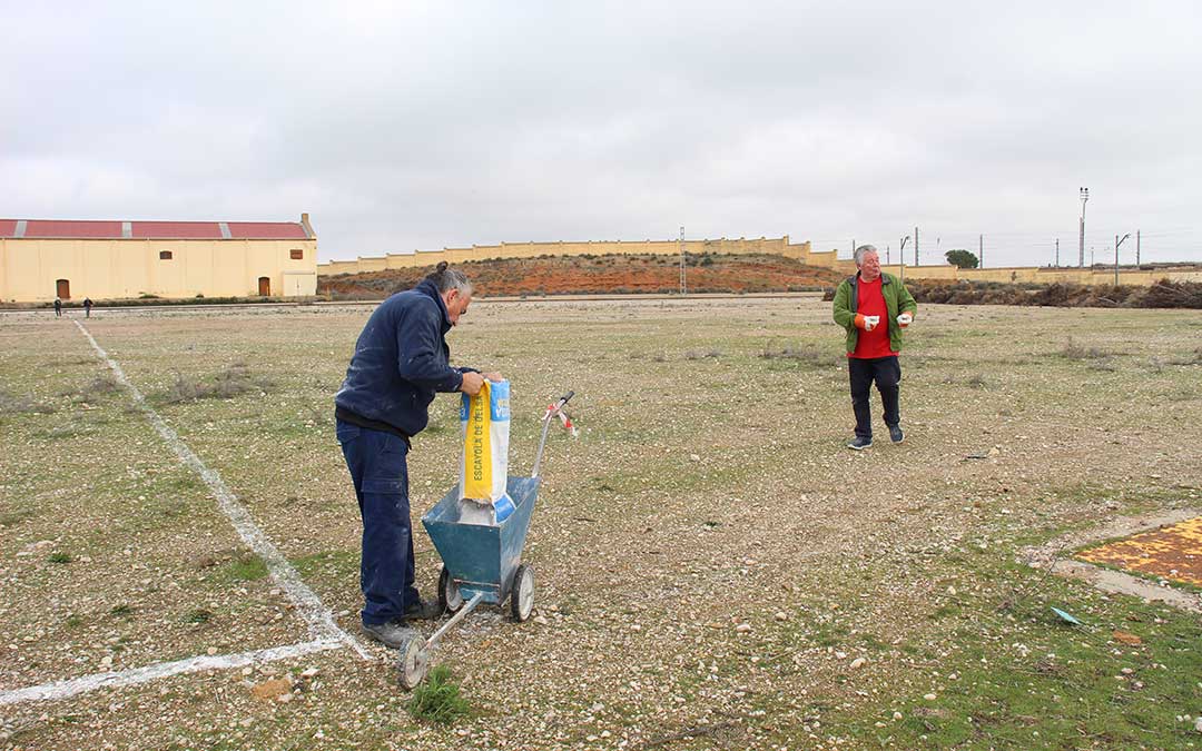 Voluntarios marcando las plazas de aparcamiento en la Azucarera a golpe de carretilla para la Tamborada Nacional. / B. Severino