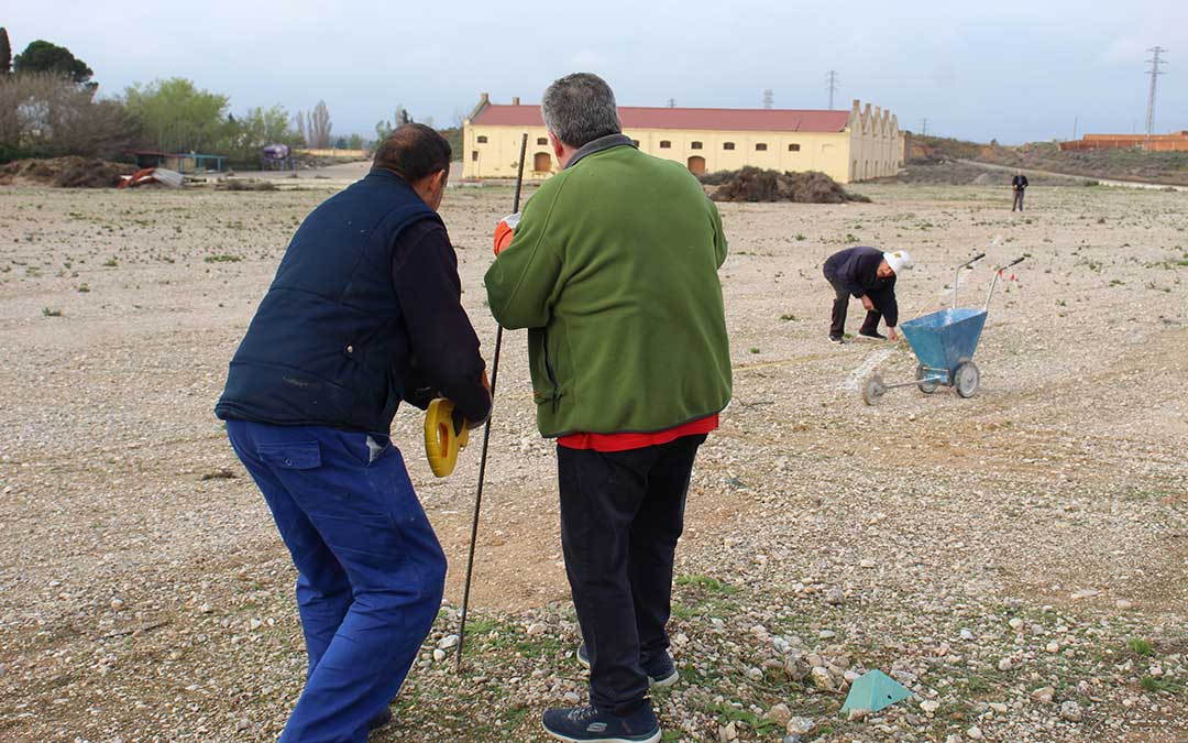 Voluntarios marcando las plazas de aparcamiento en la Azucarera a golpe de carretilla para la Tamborada Nacional. / B. Severino