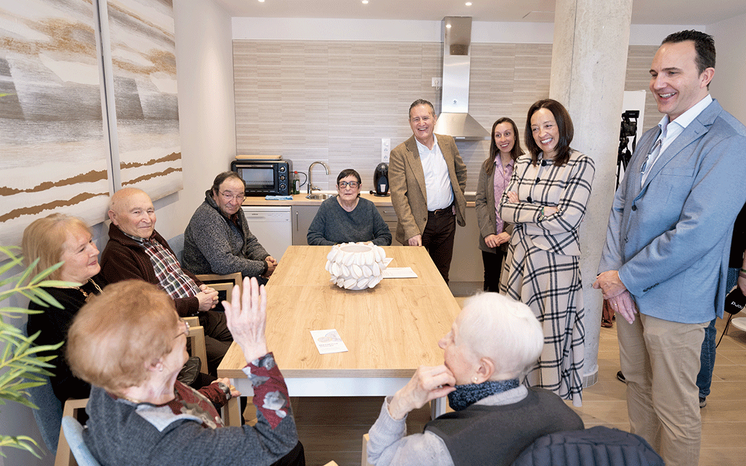 La consejera de Bienestar Social en funciones, Carmen Susín, de pie, junto al alcalde local Manuel Gascón (a la derecha de la imagen, de pie), escucha a los vecinos de Monroyo que hacen uso de las instalaciones de la Casa del Mayor puesta en marcha por el Gobierno de Aragón. / Fabián Simón/DGA
