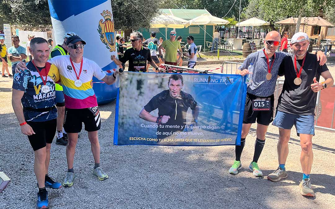 Los últimos cuatro corredores de la Backyard Ultra de Alcañiz con una bandera en honor a Rafa Esteruelas, quien siempre soñó con traer este recorrido a la capital bajoaragonesa / C.O.