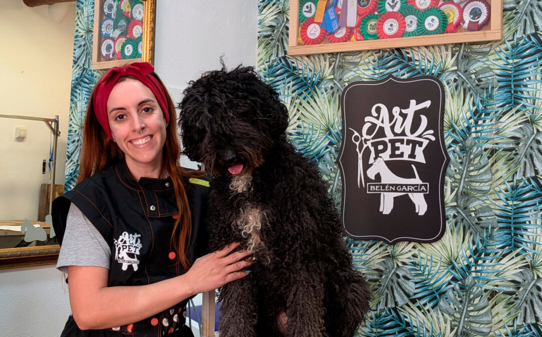 Belén García, peluquera canina del centro ArtPet de Alcañiz, en su trabajo, junto a Oneida. / E. M.