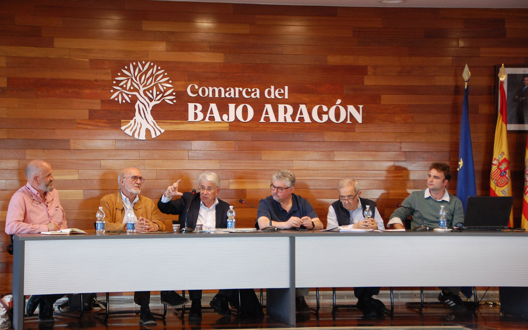 Manuel Omedas gesticulando en un momento de la charla. A la izquierda, Manuel Centelles y Carlos Estevan, tesorero y presidente de Ateneo del Bajo Aragón; en el centro, el presidente de la Comarca del Bajo Aragón, José Miguel Celma; el presidente del Sindicato Central del Guadalope, José Fernando Murria, y Manuel Omedas (hijo). / B. Severino