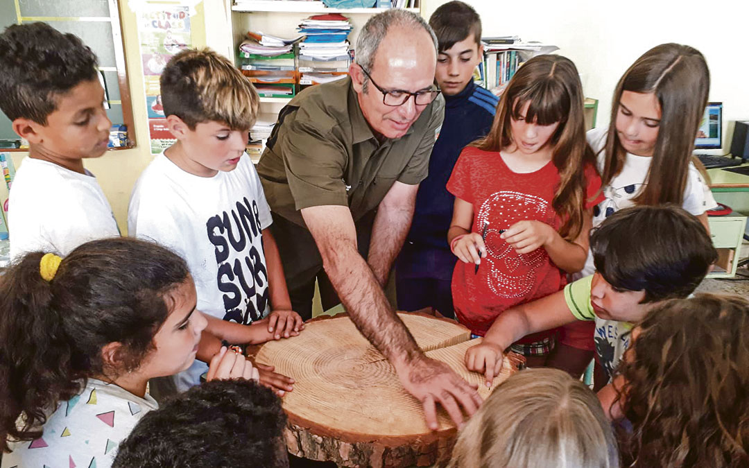 Zorrilla en la escuela de Mazaleón enseñando al alumnado cómo contar el número de años de tronco. / Archivo personal