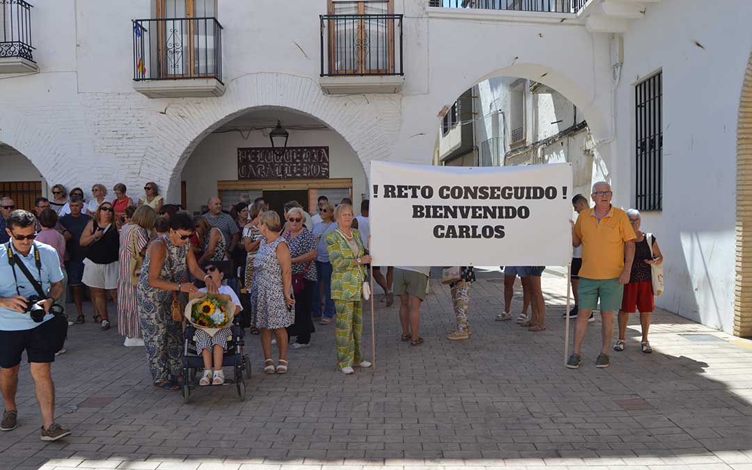 Vecinos del municipio alzando una pancarta de bienvenida a Carlos Gómez / EsHíjar