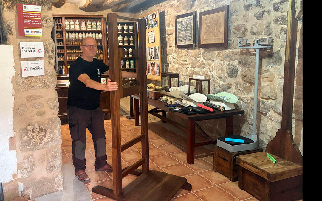 José María, presidente de la Asociación Amics de Nonasp, junto con la máquina en la farmacia del museo. / A.Z