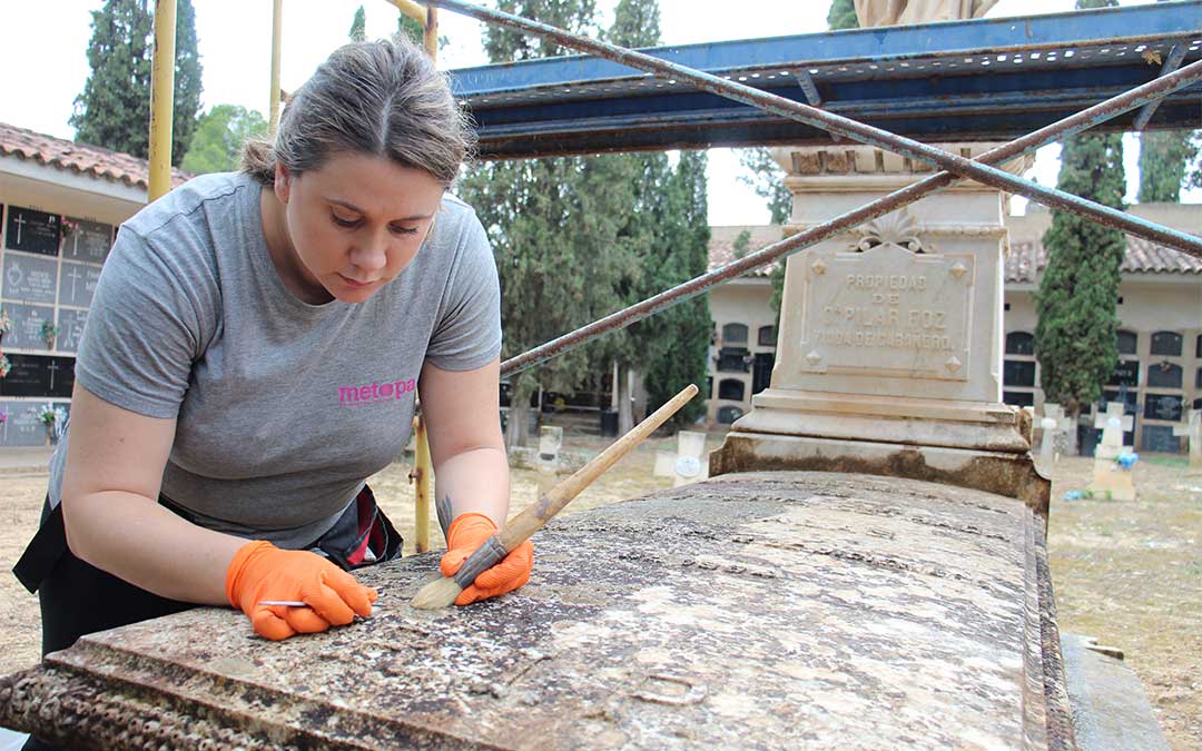 Pilar Martínez, restauradora y conservadora en METOPA, retirando líquenes del mausoleo de Vicenta Estrada del cementerio de Alcañiz. / B. Severino