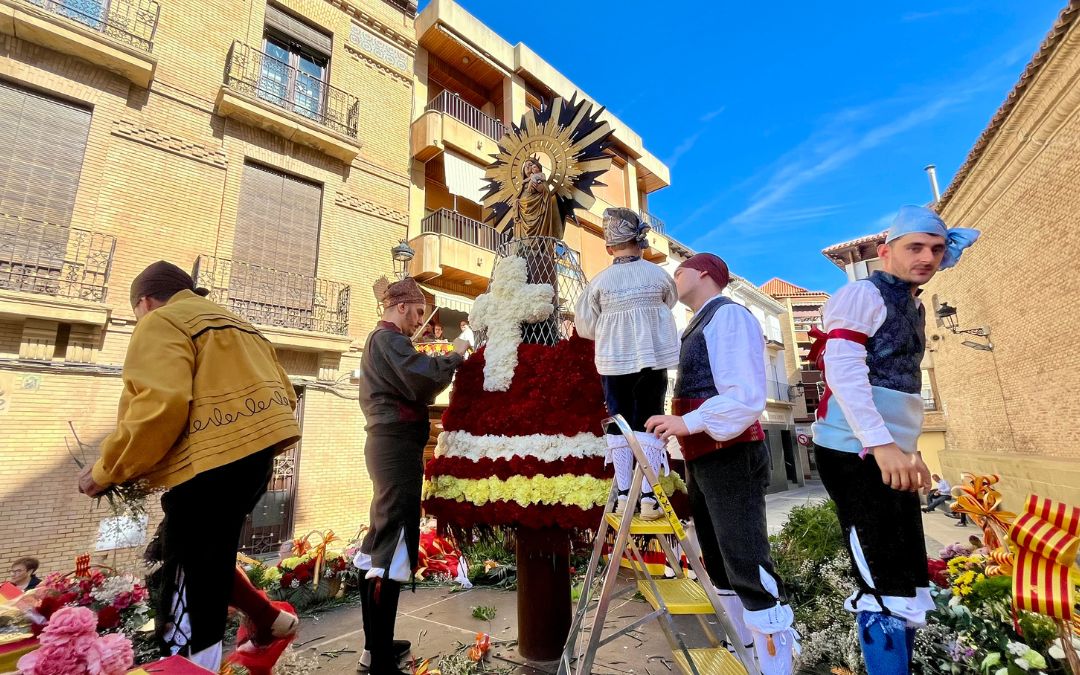El grupo de vecinos voluntarios ha vuelto a encargarse de colocar los ramos de flores para la Virgen / C.O.
